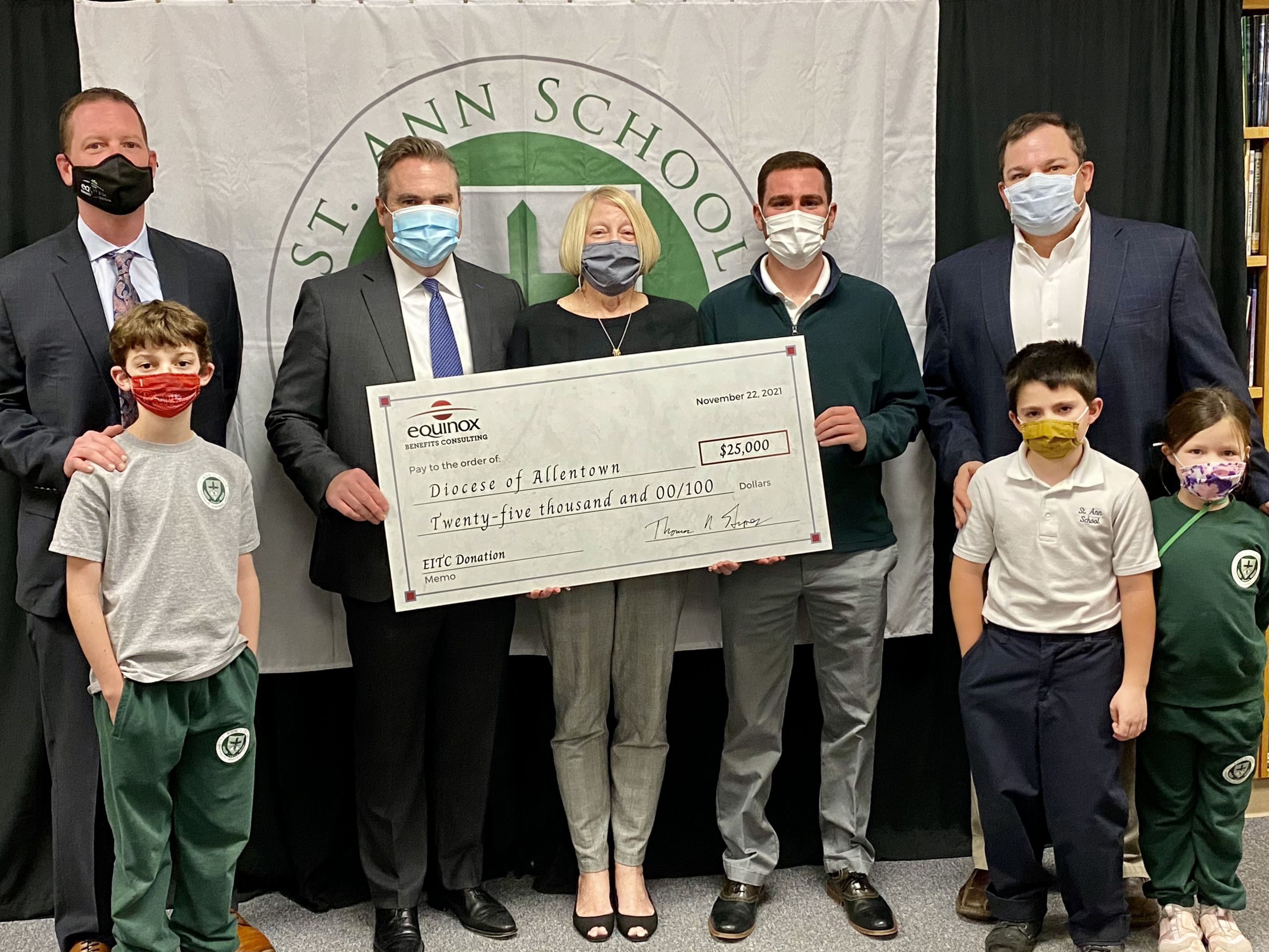 Tom Groves Presenting the scholarship donation with Equinox's Employees and their children that attend St Ann's School. (Named in order from left to right) Equinox's Benefits Consultant: Nick Maxell and his son Mason Maxell, Tom Groves, St Ann's Principle: Diana Kile, Allentown Diocese Director of Scholarships: John Fierro, Equinox's Director of Client Engagement: Adam Ulicny and his son Luke and his daughter Lilyana Ulicny.
